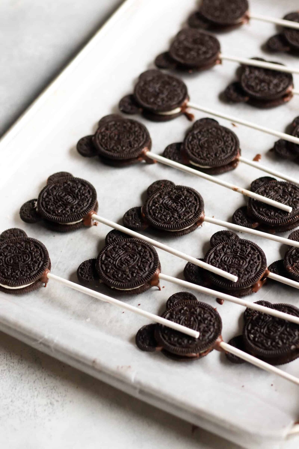 A pan of Oreo cookies on cake pop sticks that create the shape of Mickey Mouse.