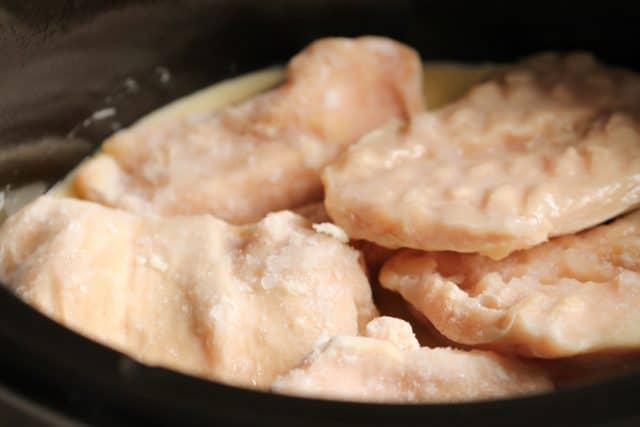 frozen chicken breasts placed in a slow cooker