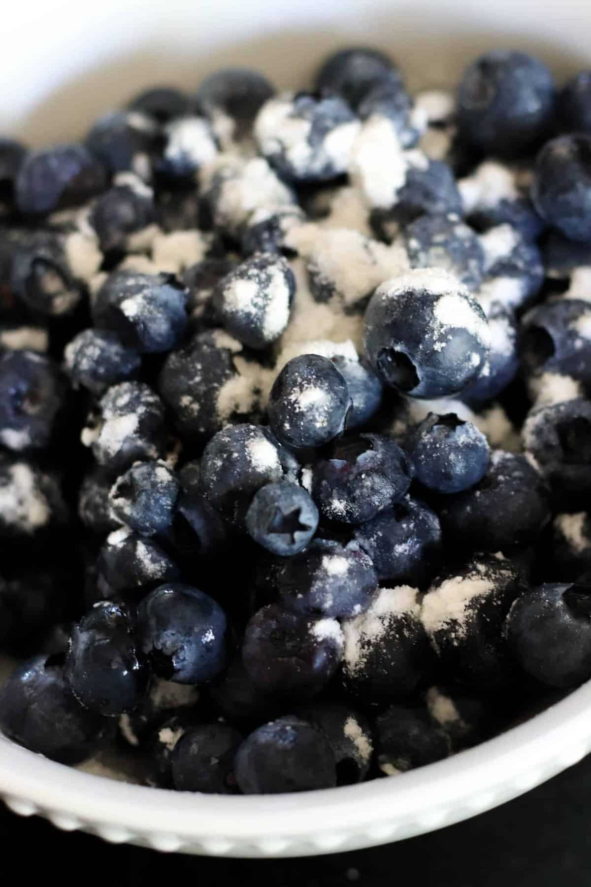 Close-up of a bowl filled with blueberries dusted with flour