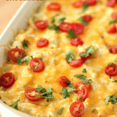 white chicken enchilada casserole with tomatoes in a baking dish