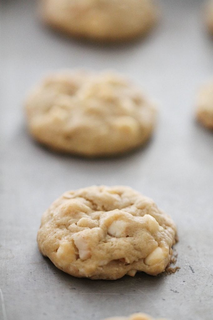 White Chocolate Macadamia Nut Cookies on a baking sheet in a row.