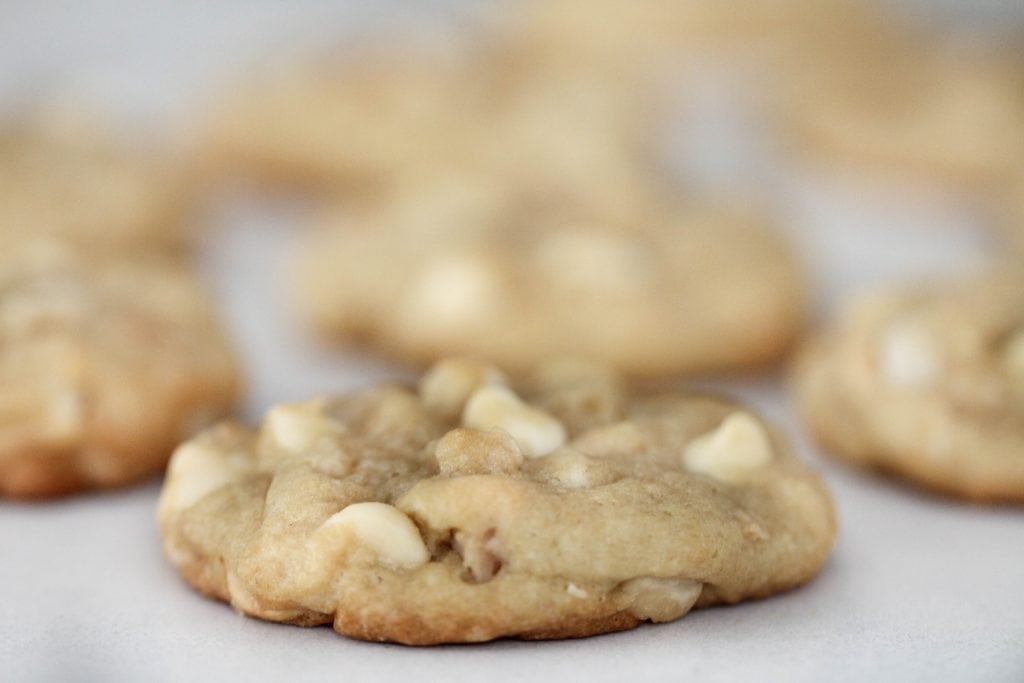 White Chocolate Macadamia Nut Cookies lined up on a white background.