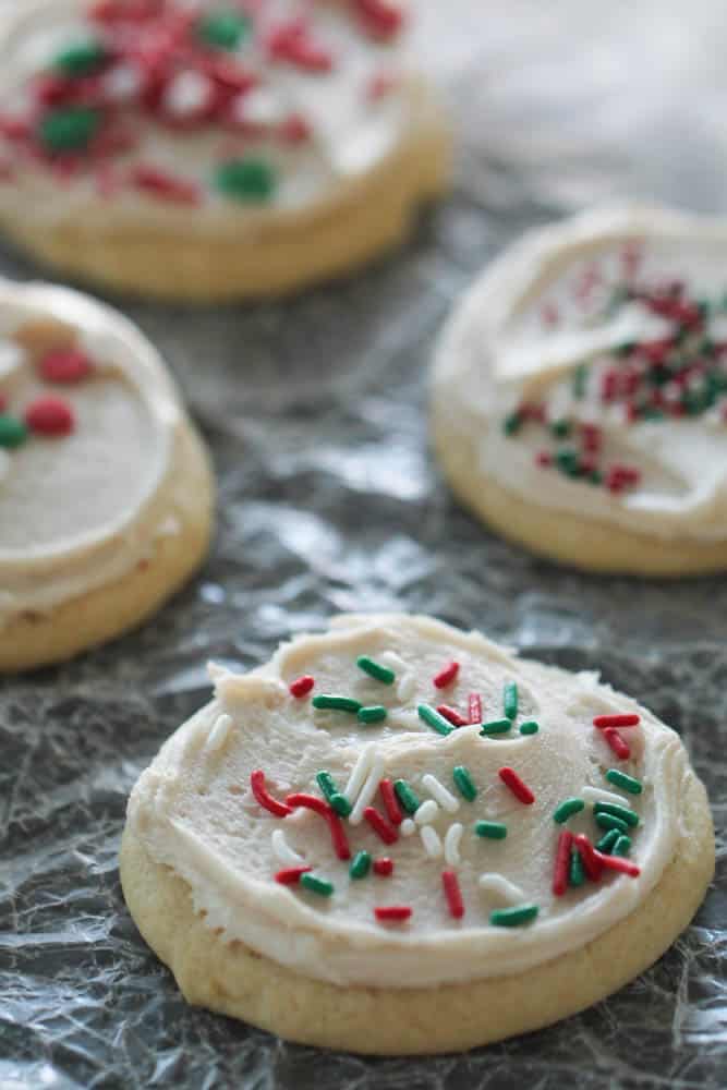 Vanilla Cookies topped with white frosting and green and red sprinkles.