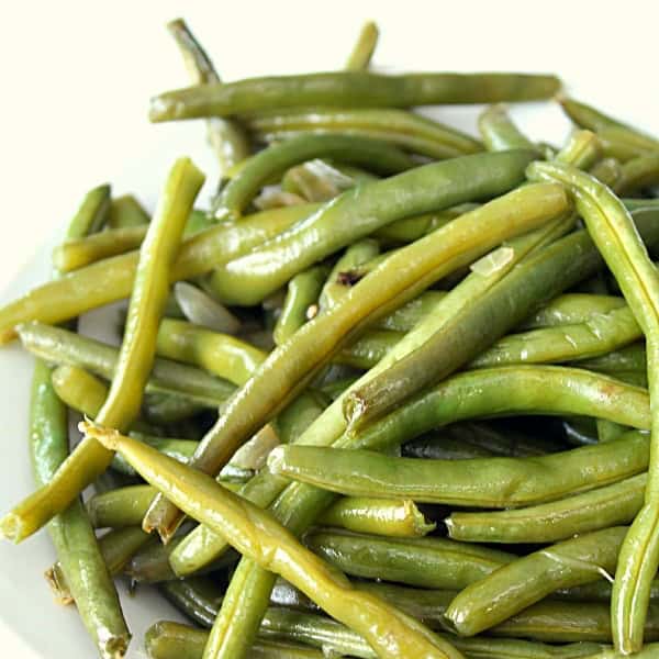 a bunch of slow cooker green beans in a white bowl