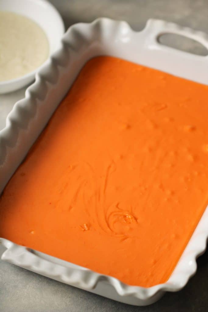 Orange Creamsicle Fudge poured into a 9x13 dish.