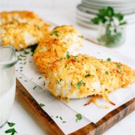 3 Easy Cheesy Ranch Chicken Breasts. 2 on a cutting board lined with parchment paper.