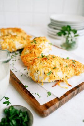 3 Easy Cheesy Ranch Chicken Breasts. 2 on a cutting board lined with parchment paper.