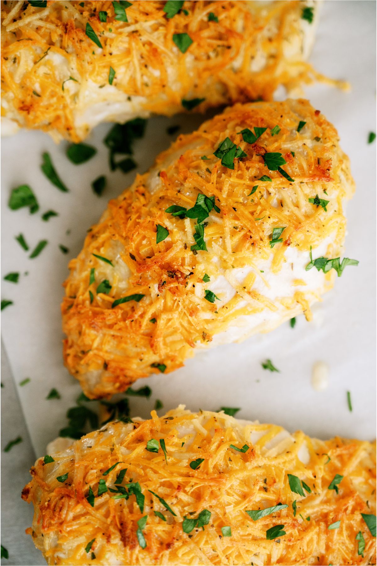 Top view of 3 Cheesy Ranch Chicken Breasts sprinkled with fresh parsley.