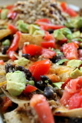 baked nachos with avocado, tomato, and olives