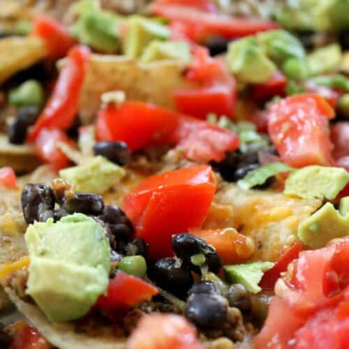 baked nachos with avocado, tomato, and olives