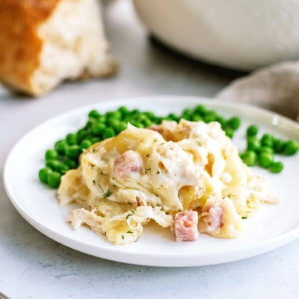 chicken cordon blue with potatoes and peas on a plate