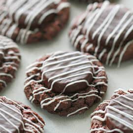 chocolate thumbprint mint cookies with icing drizzeled