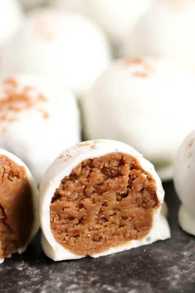 No Bake Gingerbread Cookie Truffles lined up with one cut in half to see the inside cookie filling.