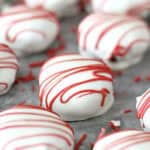 White chocolate covered Red Velvet Cake Bites lined up in rows.