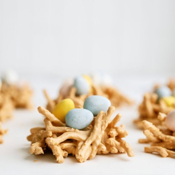 A close up of a Chow Mein Butterscotch Birds Nest Treat topped with chocolate mini eggs, with other nests in the background.