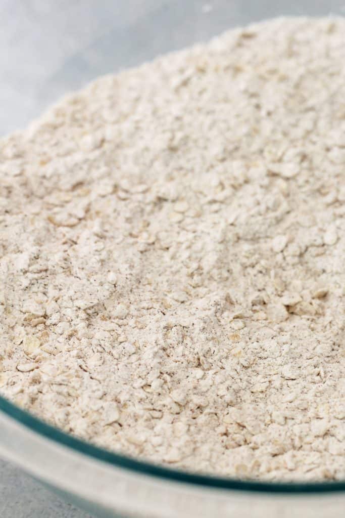 Glass mixing bowl full of dry ingredients for Oatmeal Creme Pies.