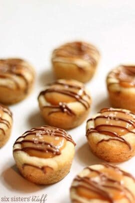 A close-up of nine small caramel-filled pastries drizzled with chocolate, arranged in rows on a white surface.