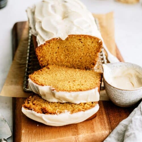 pumpkin bread with maple glaze sliced on wood cutting board