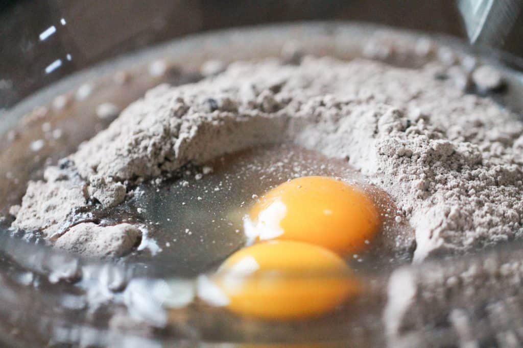 Cake mix and eggs in a glass mixing bowl.