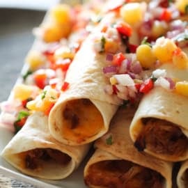 Hawaiian Pork Taquitos on a plate with fresh pineapple salsa