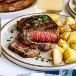 Mom's Steak Marinade Sliced Steak on a plate with potatoes