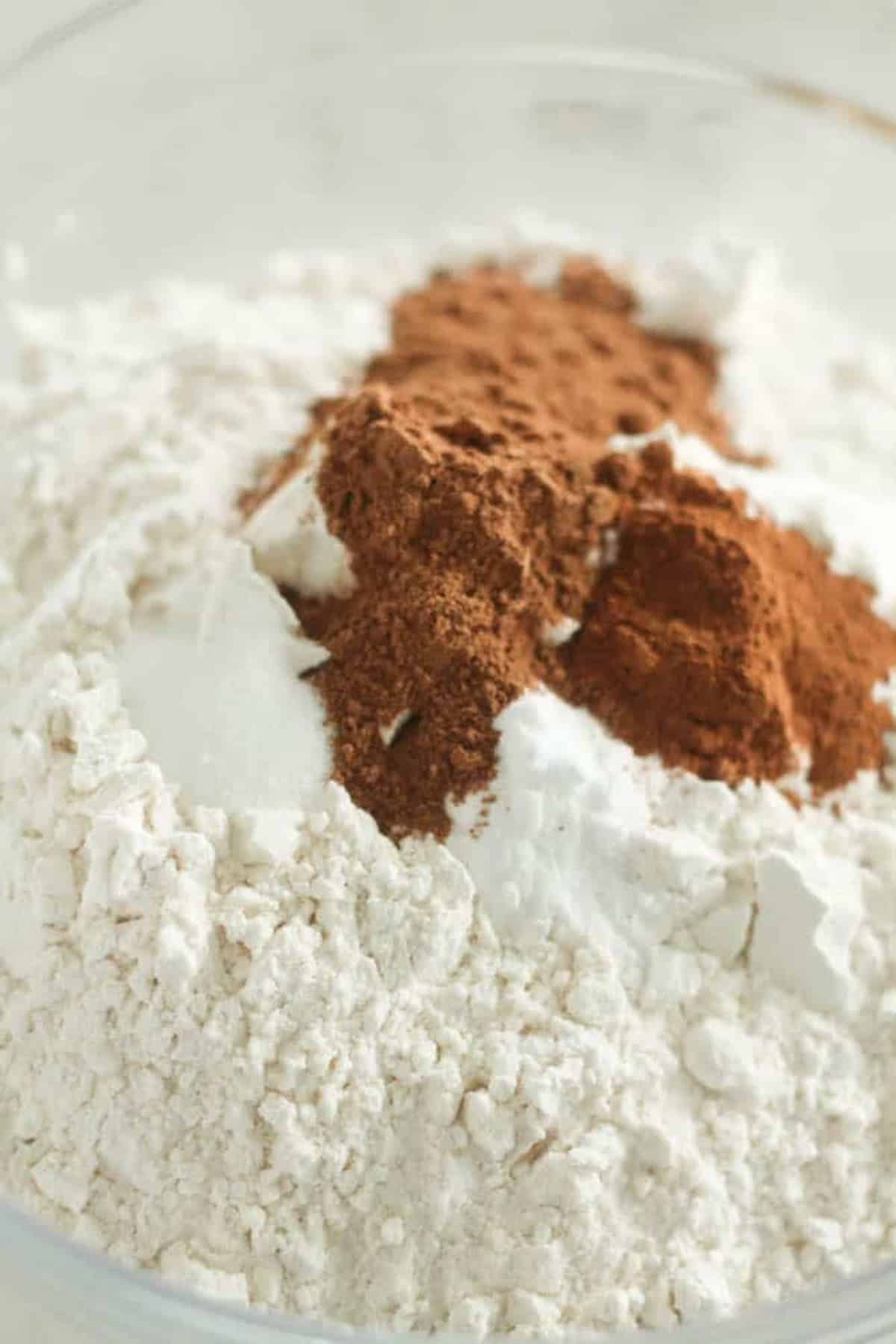 A bowl with a mixture of white flour and brown cocoa powder.