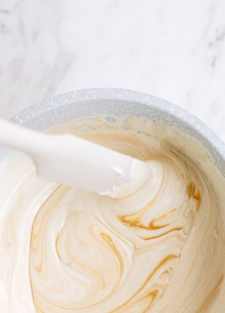 Sugar and Marshmallow mixture in a saucepan with a rubber spatula.