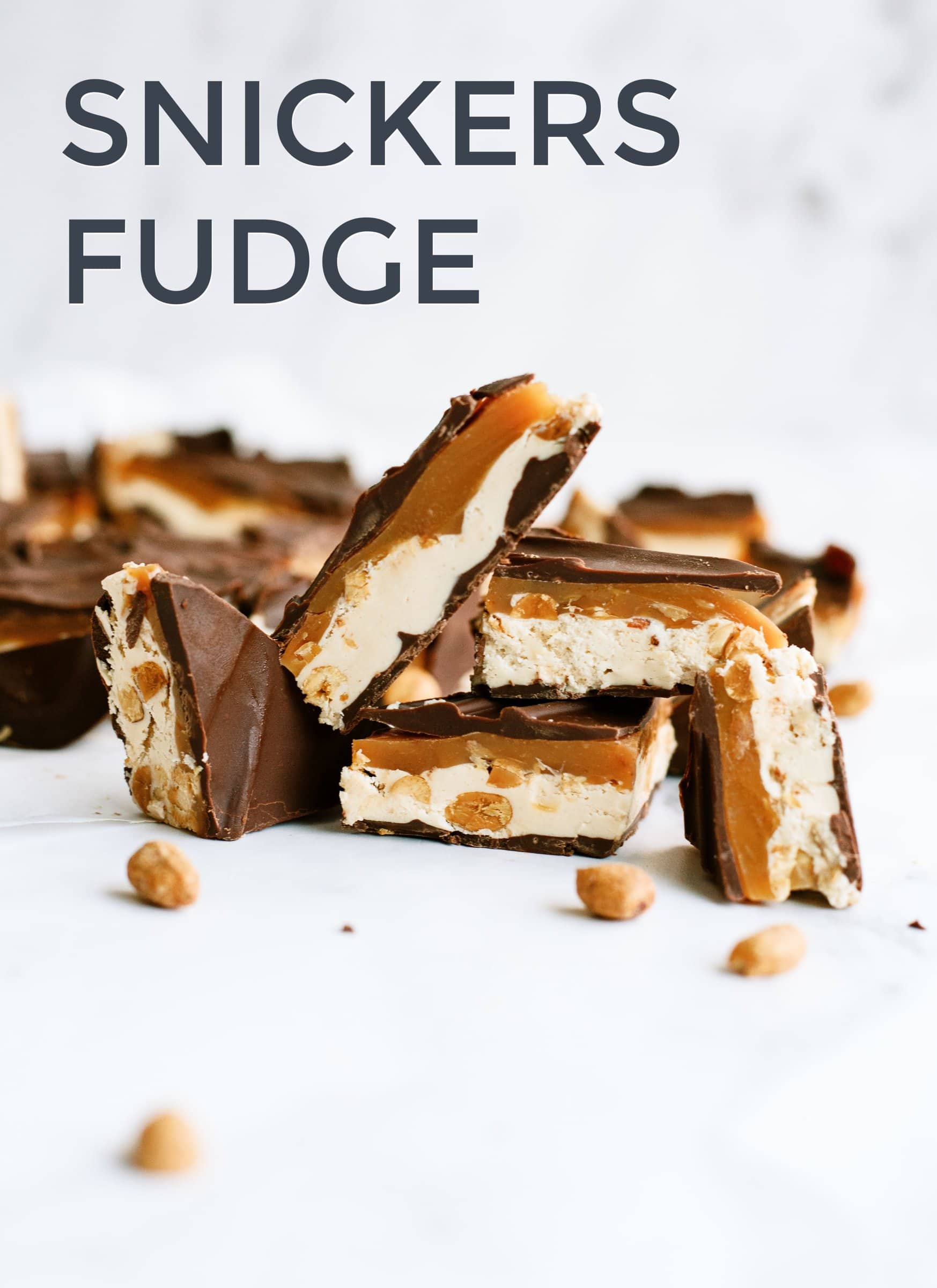 Sliced pieces of chocolate fudge with nougat, caramel, and nuts, labeled \"Snickers Fudge.