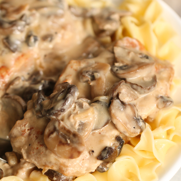 A plate of pasta topped with a creamy mushroom sauce and tender pieces of chicken.