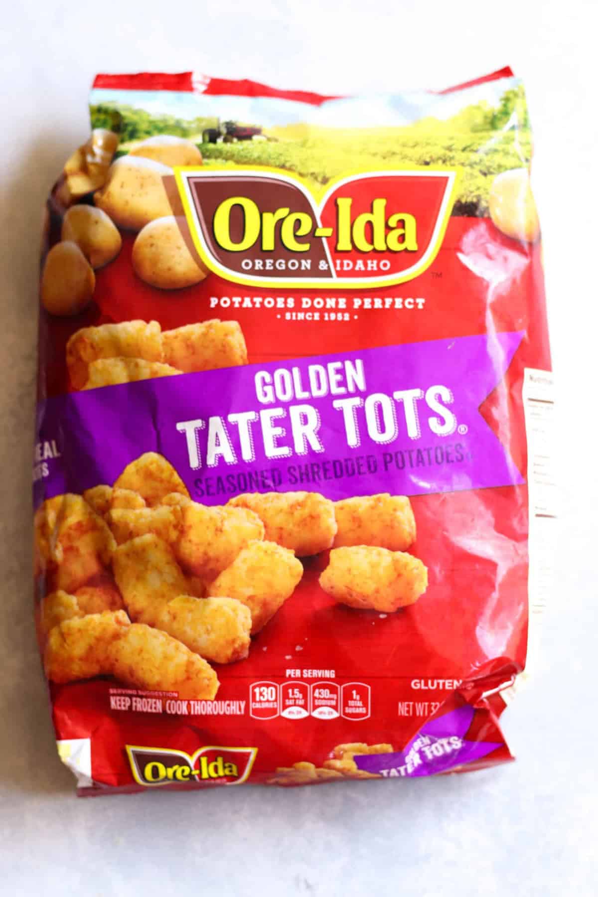 Bag of Ore-Ida Golden Tater Tots with an image of tater tots and potatoes on the packaging. Contains nutritional info and gluten-free label.