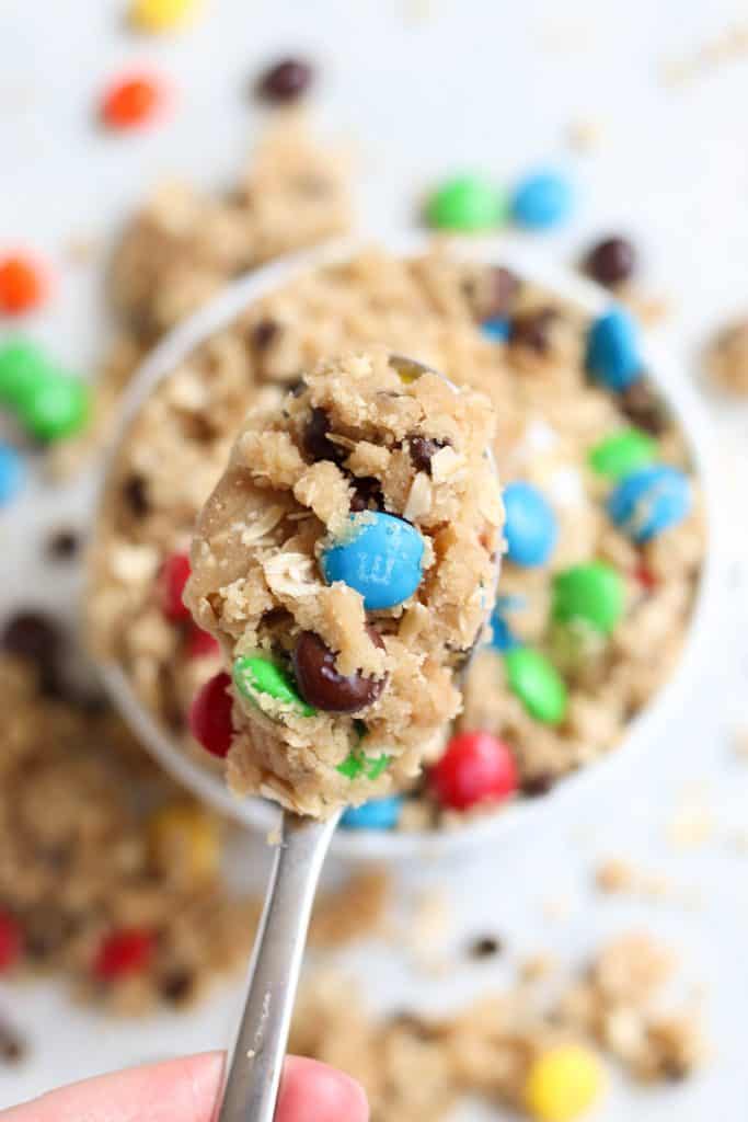 Edible Cookie Dough on a spoon being held above a small bowl of Edible Cookie Dough.