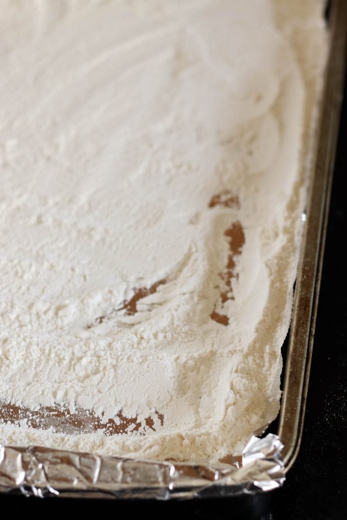 Edible cookie dough toasted flour on a baking sheet.