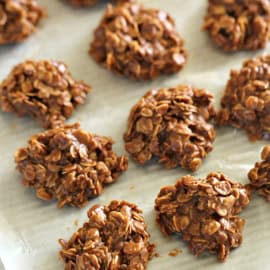 A tray of healthy no-bake cookies made with oats and chocolate, set on parchment paper.