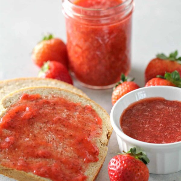 Instant Pot Strawberry Jam in a small jar and spread on a piece of bread