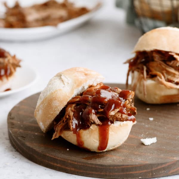 root beer pulled pork sandwich on wood cutting board