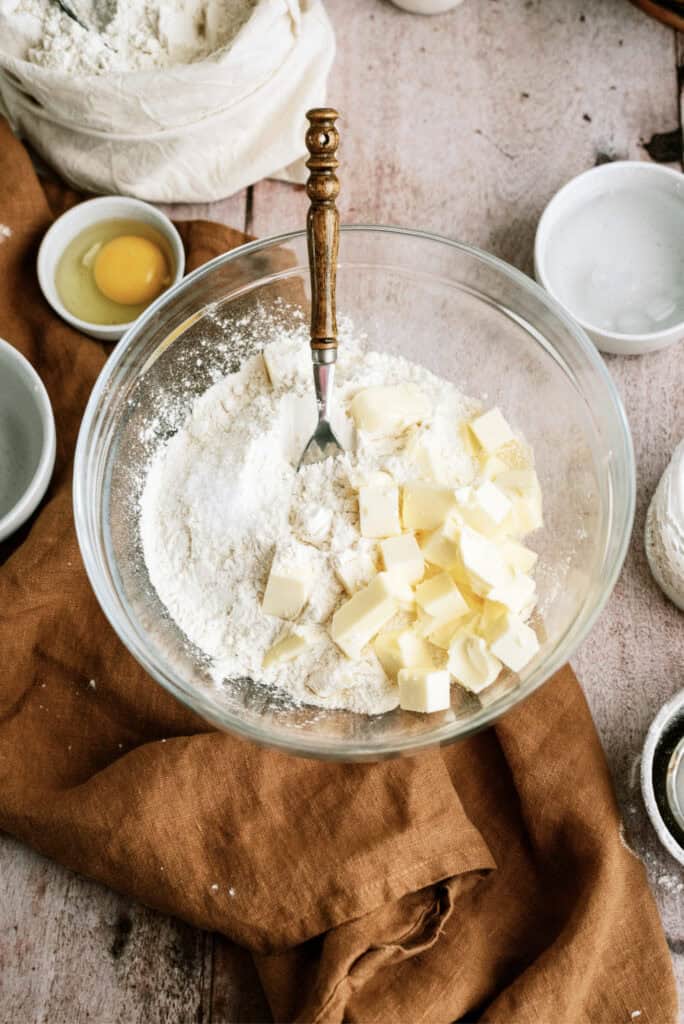 Flour and cubed butter in a mixing bowl with a fork.