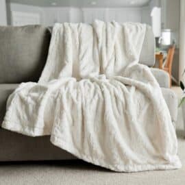 soft plush white blanket on a grey sofa