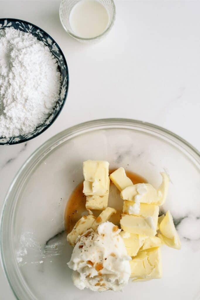 Ingredients for frosting in a glass mixing bowl.