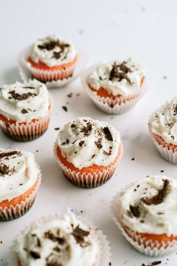 Top view of Neapolitan Cupcakes on a white background frosted and topped with little chocolate pieces.