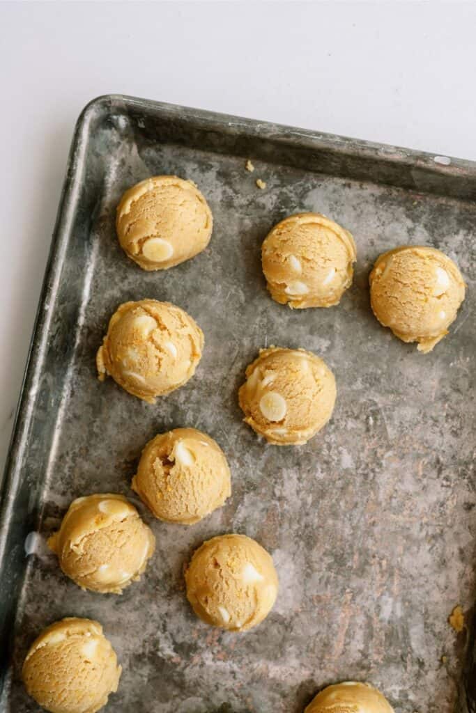 Orange Creamsicle Cookie cookie dough balls on a baking sheet.