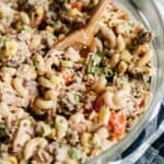Cowboy Pasta Salad in a large bowl with a wooden spoon