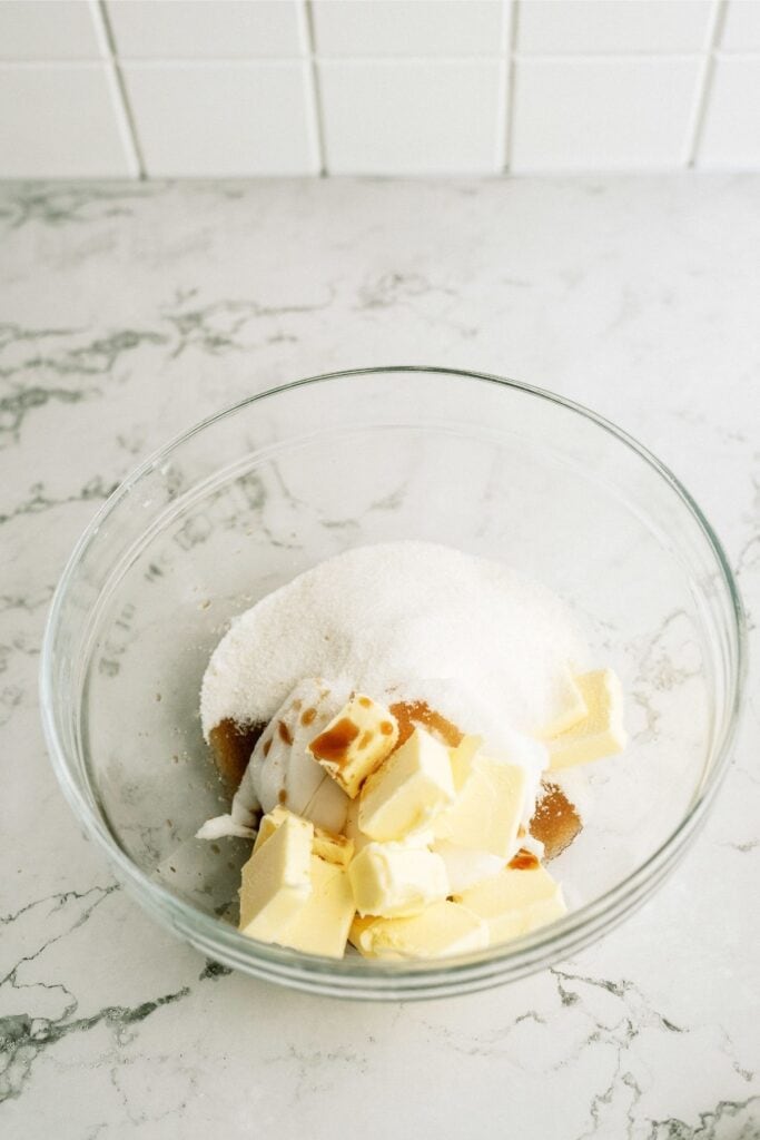 Sugar butter and bananas in a glass mixing bowl.