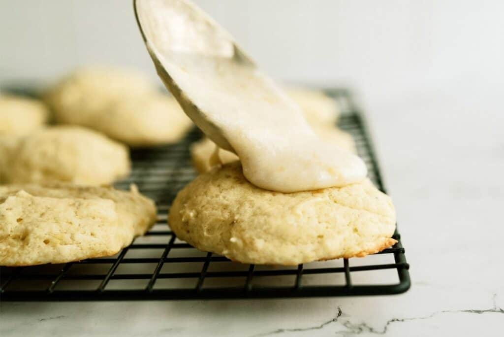 Spooning frosting on top of baked Banana Cookies