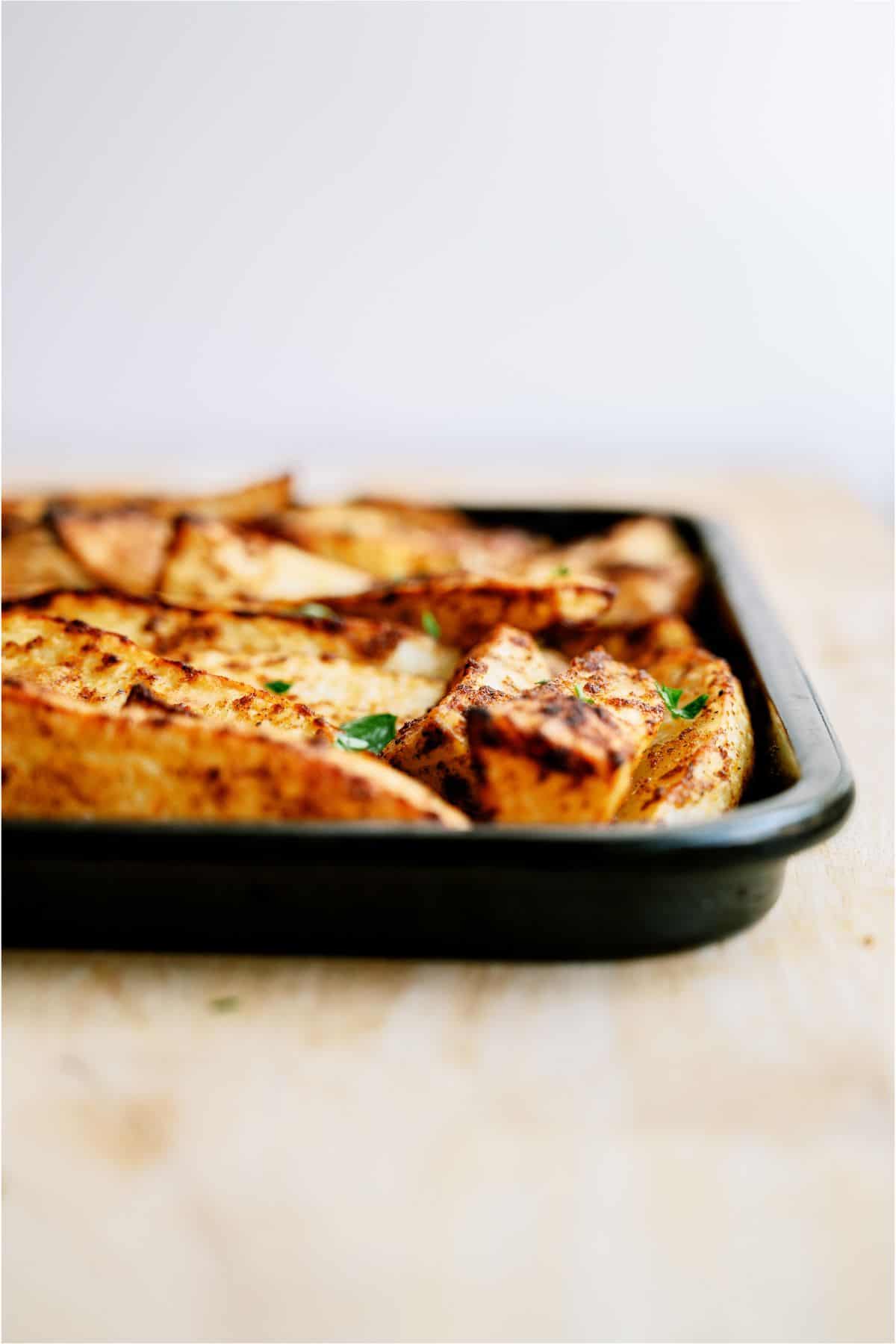 Side view of a sheet pan of Oven Baked Seasoned Steak Fries