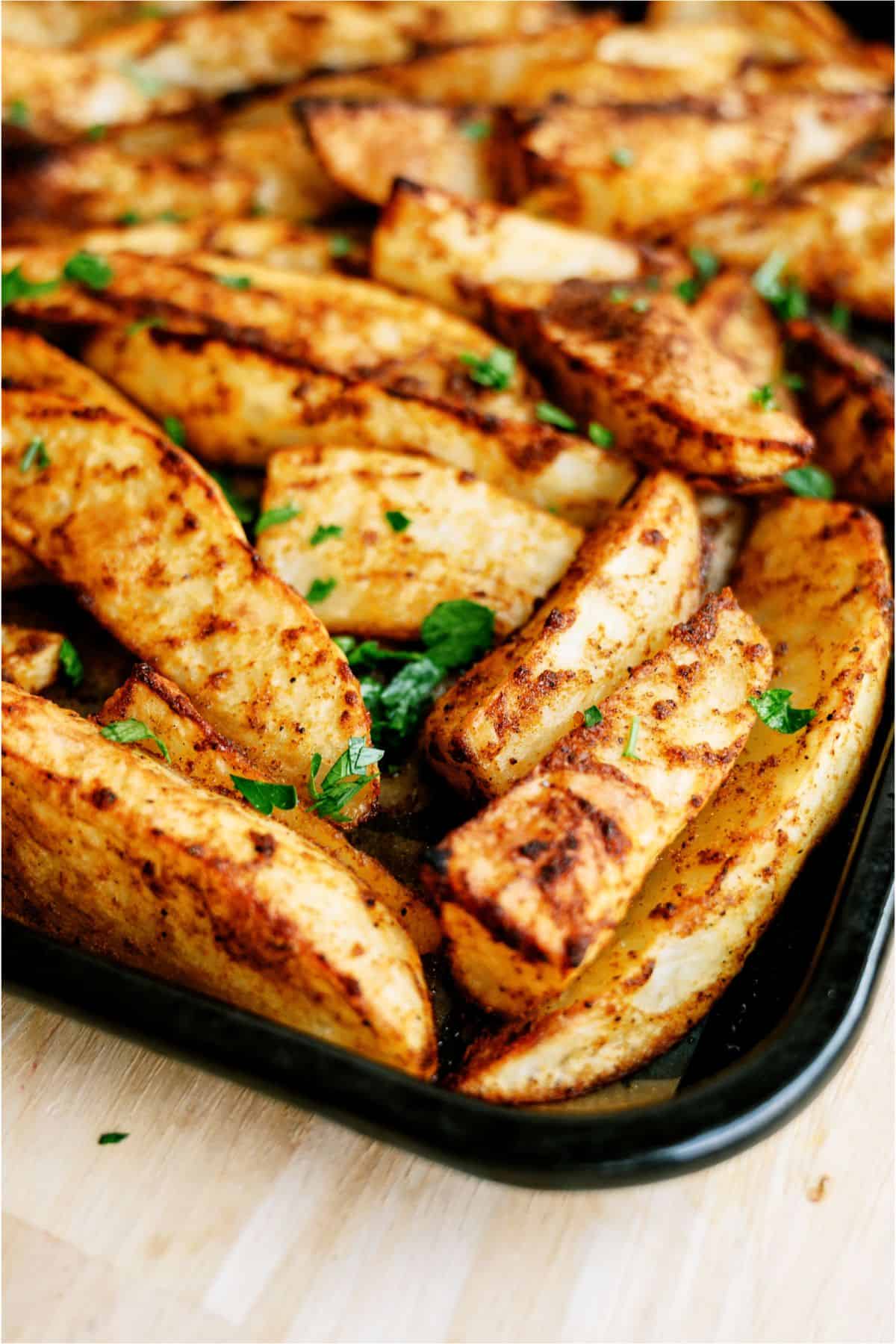 Close up of Oven Baked Seasoned Steak Fries on a sheet pan