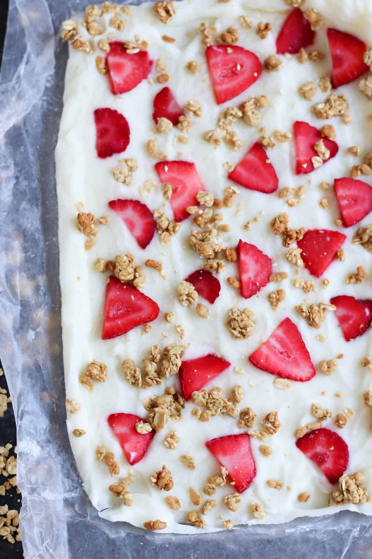 Strawberry Granola Yogurt Bark in a pan lined with parchment paper.