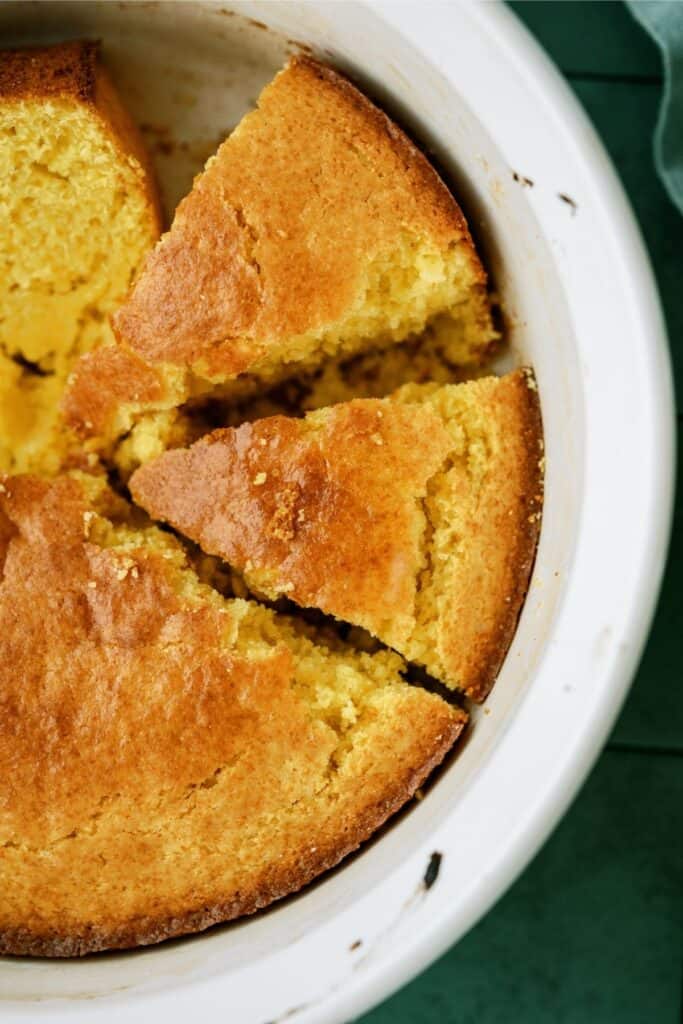 Easy Homemade Cornbread in a white baking dish, sliced into pie shape.