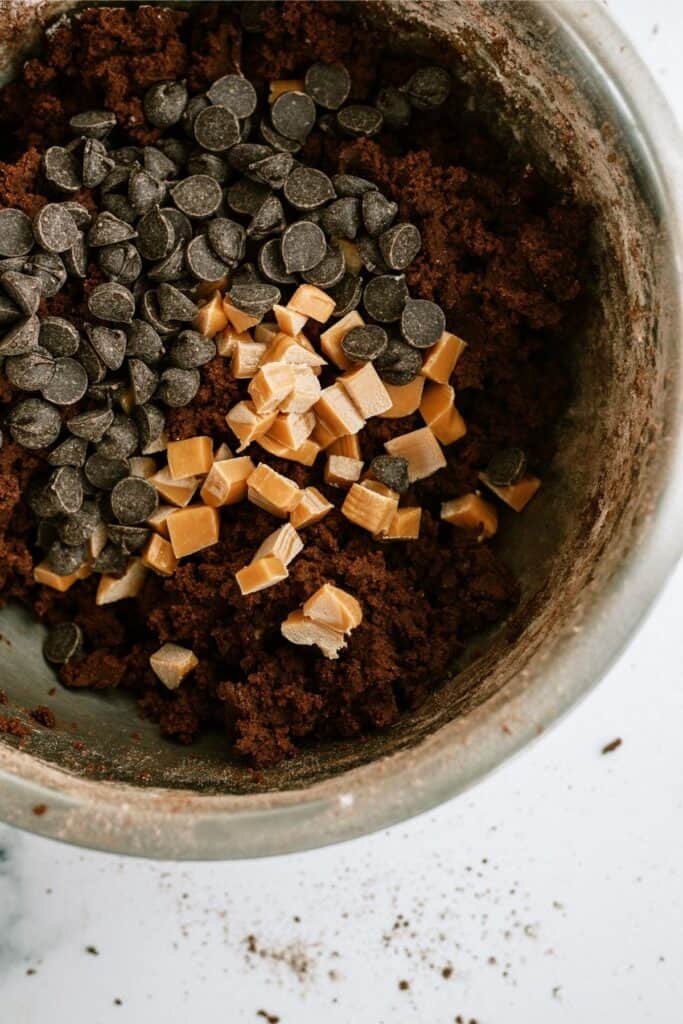 Chocolate chips and cubed caramel bits added to chocolate cookie dough.