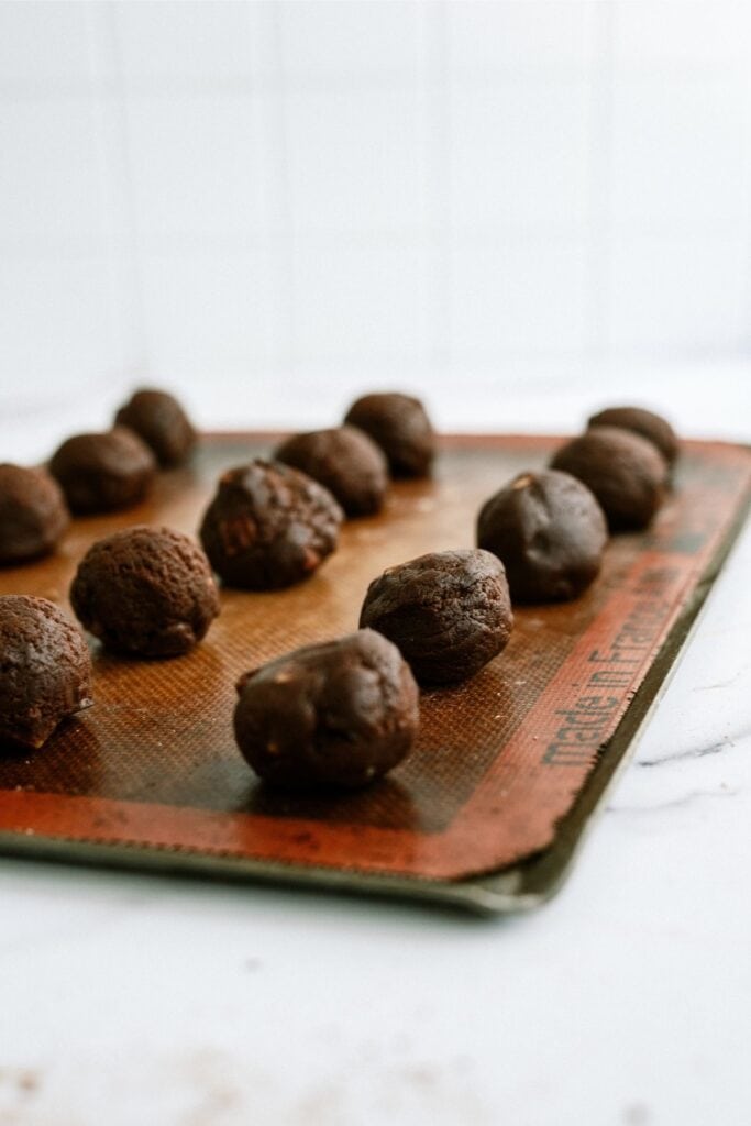 Salted Caramel Chocolate Cookie dough balls on a baking sheet lined.