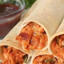 Three rolled tortillas filled with shredded chicken and melted cheese, served with a side of BBQ sauce.